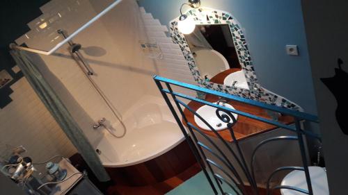 a bathroom with a tub and a sink and a mirror at B&B Le Bonimenteur in Charleroi