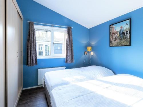 a blue bedroom with a bed and a window at Nature Retreat for Groups in De Bult