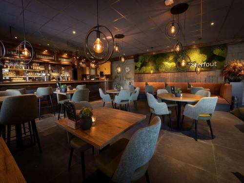 a restaurant with tables and chairs and a bar at Chalet by Pond in Holiday Park in Veldhoven
