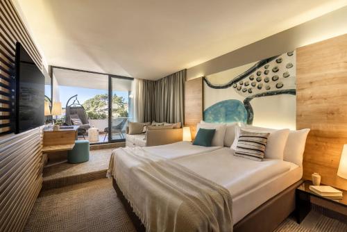 a hotel room with a large bed and a living room at Valamar Padova Hotel in Rab
