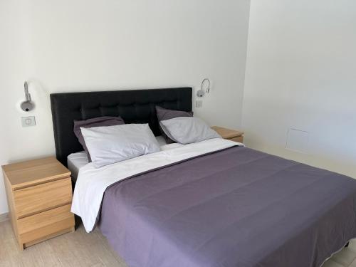 une chambre avec un grand lit avec deux tables de nuit dans l'établissement Villa Rougiers - Maison climatisée avec piscine, à Saint-Maximin-la-Sainte-Baume