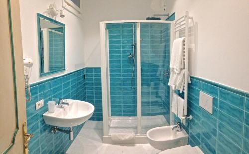 a blue tiled bathroom with a sink and a shower at Hotel Villa Delle Palme in Positano in Positano