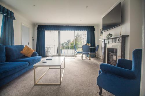 a living room with blue couches and a table at Allerdale in Torquay
