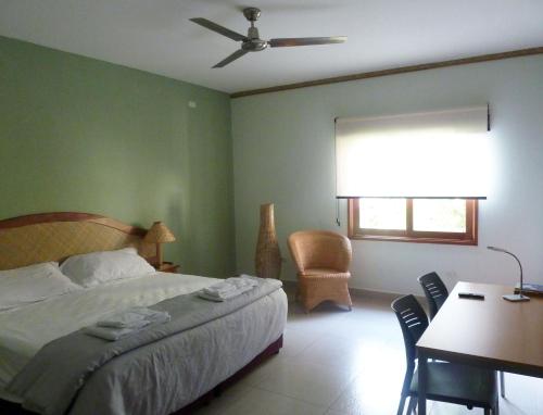 a bedroom with a bed and a table and a window at Hotel Casa Vínculos in Estelí