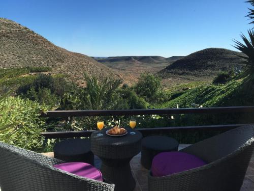 a patio with chairs and a table with wine glasses at La Almendra y El Gitano in Agua Amarga