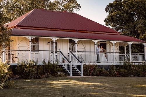 a woman standing on the porch of a white house at Linning's House at Twigley Farm in Marburg