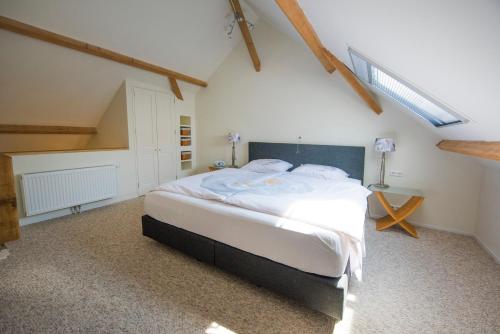 a bedroom with a large bed in a attic at B&B Louisehoeve in Linschoten