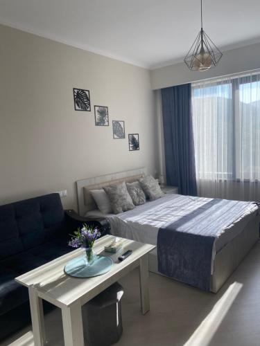 a bedroom with a bed and a table and a couch at Sun Alvina Tsaghkadzor in Tsaghkadzor