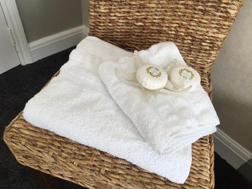 two towels sitting on top of a wicker chair at Edgware B&B in Barnet