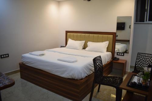 a bedroom with a large bed and a chair at Hotel Deluxe in Rānchī