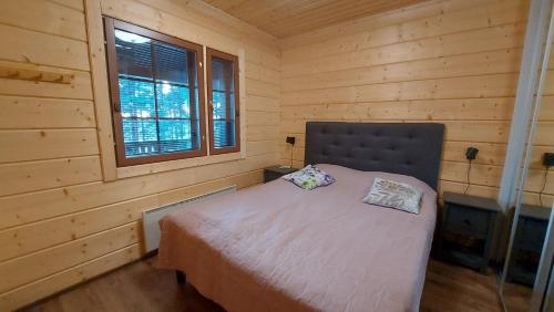 a bedroom with a bed in a wooden cabin at Porotieva in Posio