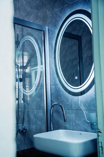 a bathroom with a sink and two round mirrors at Comfort away from home 1 in Mutanga