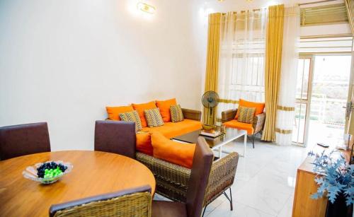 a living room with an orange couch and a table at Comfort away from home 1 in Mutanga