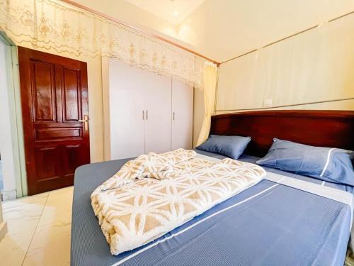 a bedroom with a large bed with a wooden headboard at Comfort away from home 1 in Mutanga