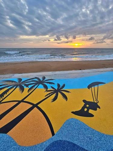 a painting of a beach with an umbrella and palm trees at บ้านพิม in Pran Buri