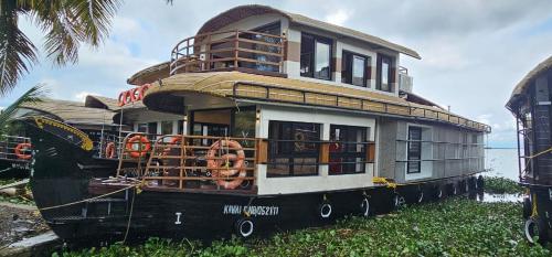a house boat is sitting on the grass at Dreams Spectrum Luxury houseboat in Alleppey