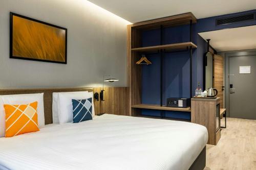 a bedroom with a large white bed and blue walls at Four Points Flex by Sheraton Ankara Cukurambar in Ankara
