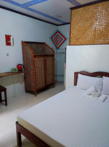 a bedroom with a bed and a bird cage at ALFA Garden Lodge in El Nido
