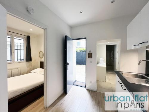 Il comprend une chambre avec un lit et une cuisine avec un évier. dans l'établissement Urban Flat 181 - Pretty Flat in Levallois, à Levallois-Perret