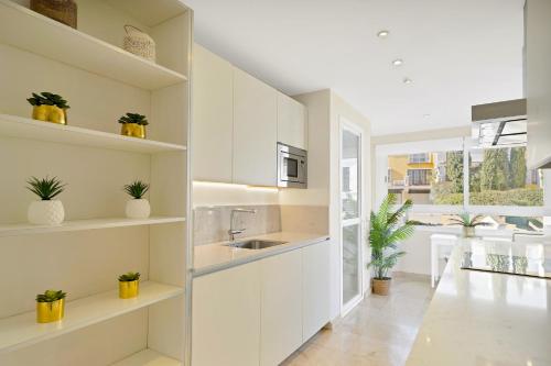 a kitchen with white cabinets and potted plants at Luxury Duplex Penthouse Sea Views in Marbella Golden Mile in Marbella