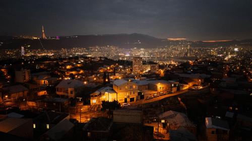 a view of a city at night at Panorama Hills Apart-Hotel in Tbilisi City