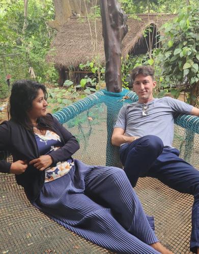 a man and a woman sitting on a hammock at Chika's Place River View Udawalawa in Udawalawe