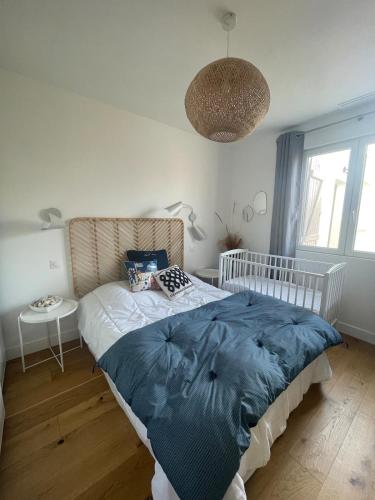 une chambre avec un lit avec une couverture bleue dans l'établissement Maison La Julise, Piscine & Mer, au Croisic