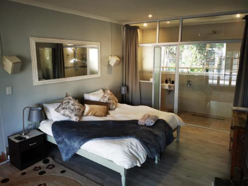 a bedroom with a large bed and a bathroom at Walmer Heights Guest House in Port Elizabeth