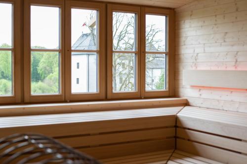 a room with four windows and a chair at Hotel Stiegl-Gut Wildshut in Wildshut
