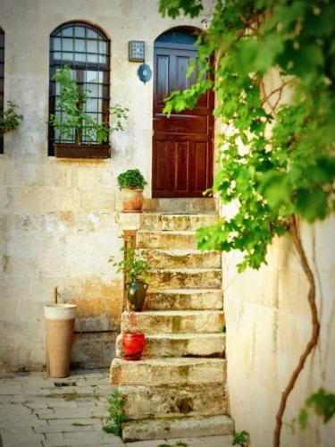 a house with a wooden door and stairs in front at Bey Konağı Butik Otel in Şahinbey