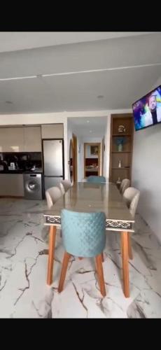 a dining room with a table and a blue chair at The Happy House in Kelibia