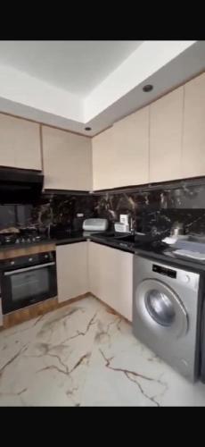 a kitchen with a stove and a washing machine at The Happy House in Kelibia