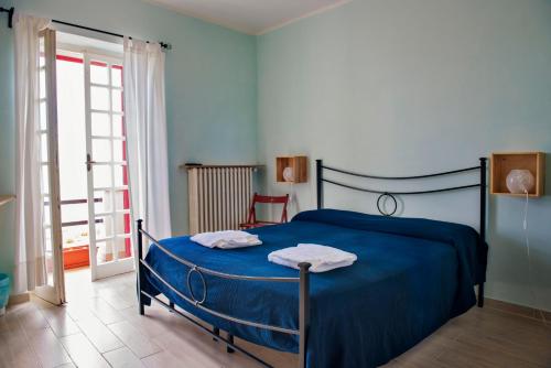 a bedroom with a blue bed with two towels on it at Azzurromare in San Vito Chietino