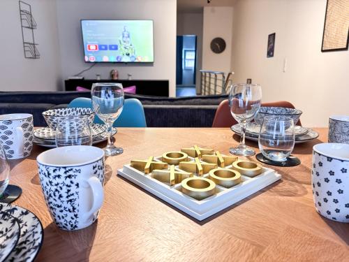 a table with a plate of food on a table with glasses at ThinkPink! Apartment im Herzen Dortmunds in Dortmund