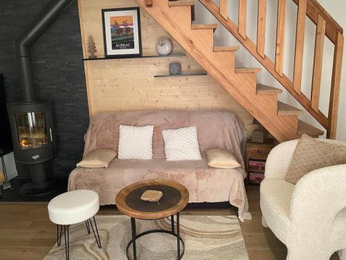 un salon avec un canapé et un escalier dans l'établissement Chalet chaleureux et fonctionnel, à Laguiole