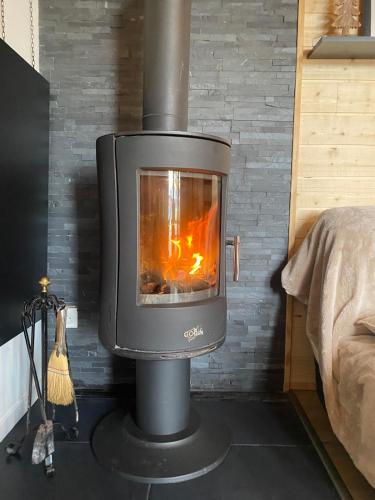 - une cuisinière avec une cheminée dans la pièce dans l'établissement Chalet chaleureux et fonctionnel, à Laguiole