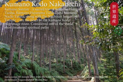 a sign in the middle of a forest of trees at KAMENOI HOTEL Kii-Tanabe in Tanabe