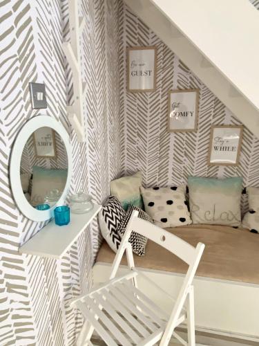 a room with a staircase with a chair and a mirror at Seaview Cottage on the Island in Millbay