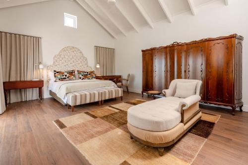 a bedroom with a king sized bed and a chair at Island lifestyle on the water in Knysna