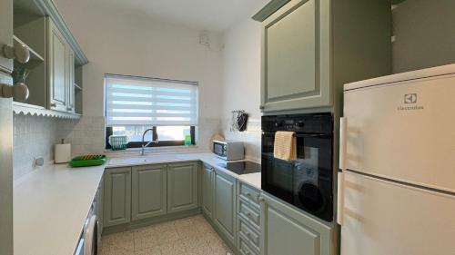 Taʼ XbiexにあるSpaciously Cosy 3BD Accomodation in Ta Xbiex - Yacht Marina & Valletta Viewsのキッチン(緑のキャビネット、白い冷蔵庫付)