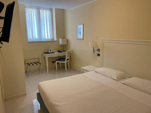 a bedroom with a bed and a table and a desk at Residence Atlantic in Alassio