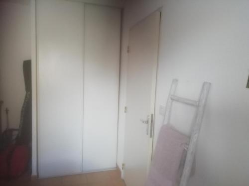 une chambre avec deux armoires blanches et une échelle dans l'établissement location d'une chambre au calme dans un appartement, à Nîmes