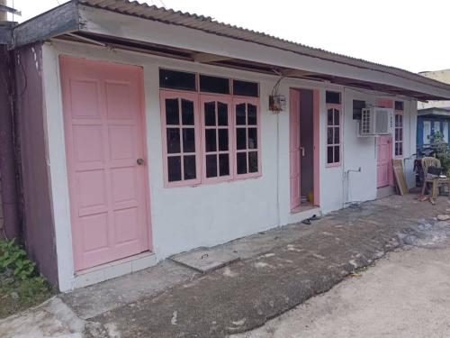a small house with pink doors on it at Perhentian Alia guest house in Perhentian Island