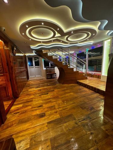 a large room with a staircase and wooden floors at Dreams Spectrum Luxury houseboat in Alleppey