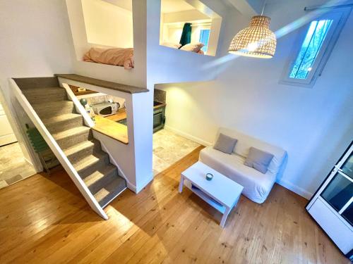 a small room with a staircase with a couch and a table at " Studio Vasconia " Hyper Centre - Mezzanine -Wifi in Muret