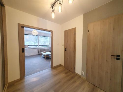 an empty room with a door and a window at Apartmán na horách Malá Morávka in Malá Morávka