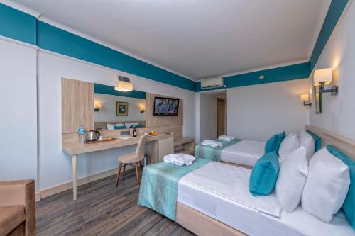 a hotel room with two beds and a desk at Asteria Collection Side in Side