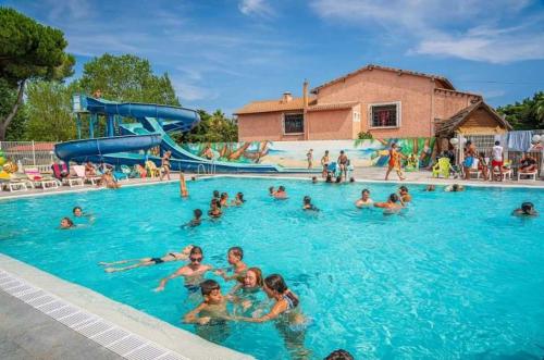un groupe de personnes nageant dans une piscine dans l'établissement Camping - Parc aquatique - ccahfd0, à Portiragnes