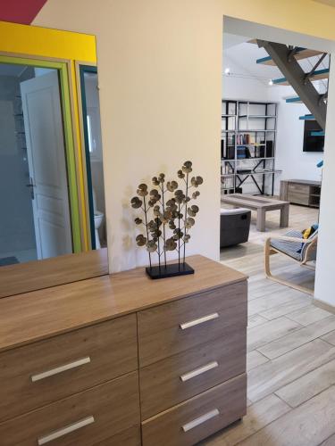 - une commode avec un vase dans le salon dans l'établissement L'oasis des fleurs, à Saint-André-de-Sangonis