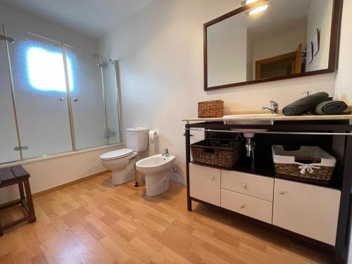 a bathroom with a toilet and a sink and a mirror at Terrasol Chalet en Torre Del Mar in Torre del Mar